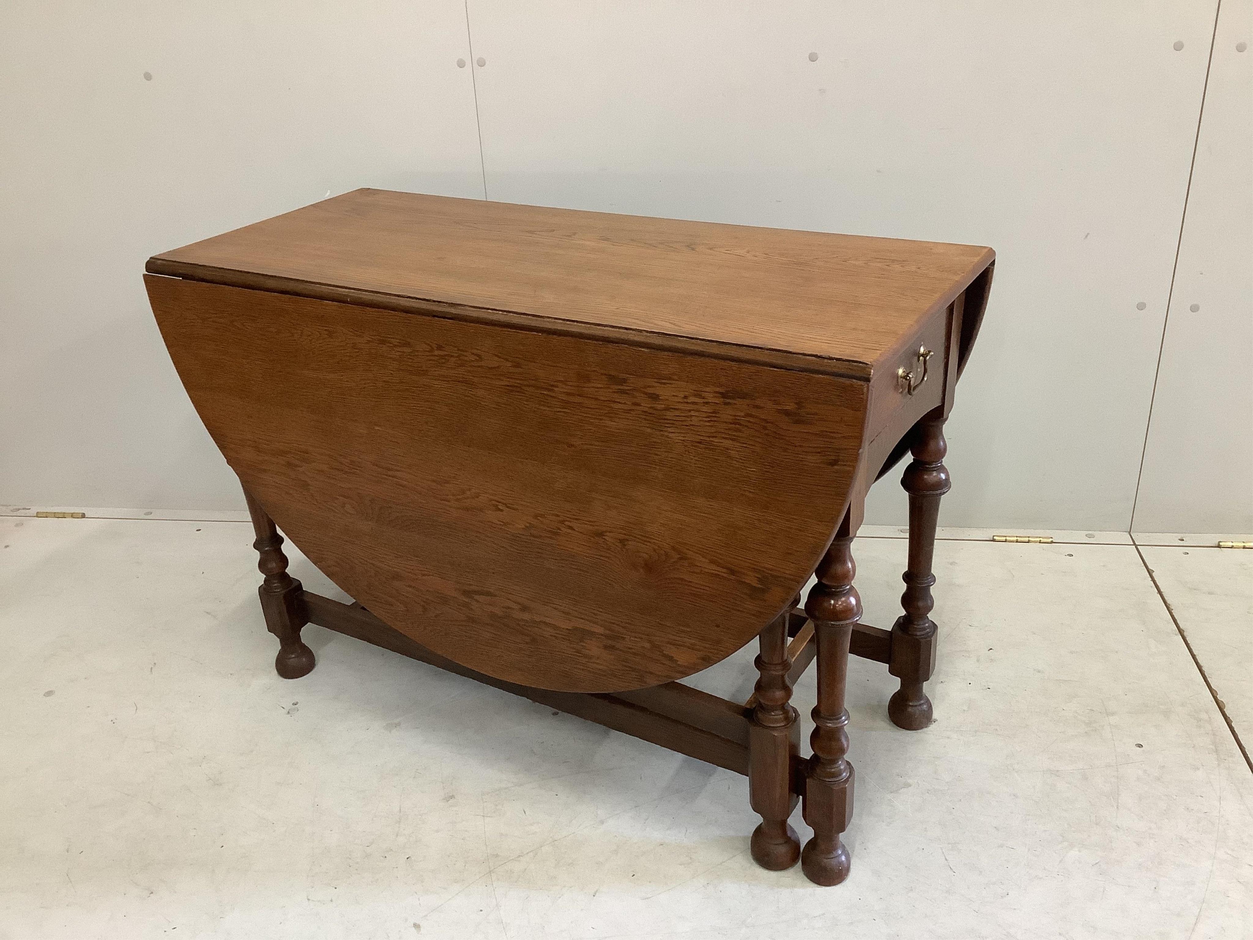 An early 20th century oak gateleg dining table, width 107cm, depth 47cm, height 74cm. Condition - fair to good